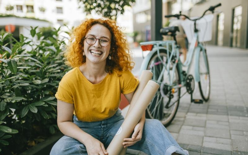 Close to the center of everything woman sitting on a sidewalk next to a bicycle