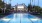 a swimming pool in front of clubhouse with palm trees