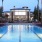 a swimming pool in front of clubhouse with palm trees